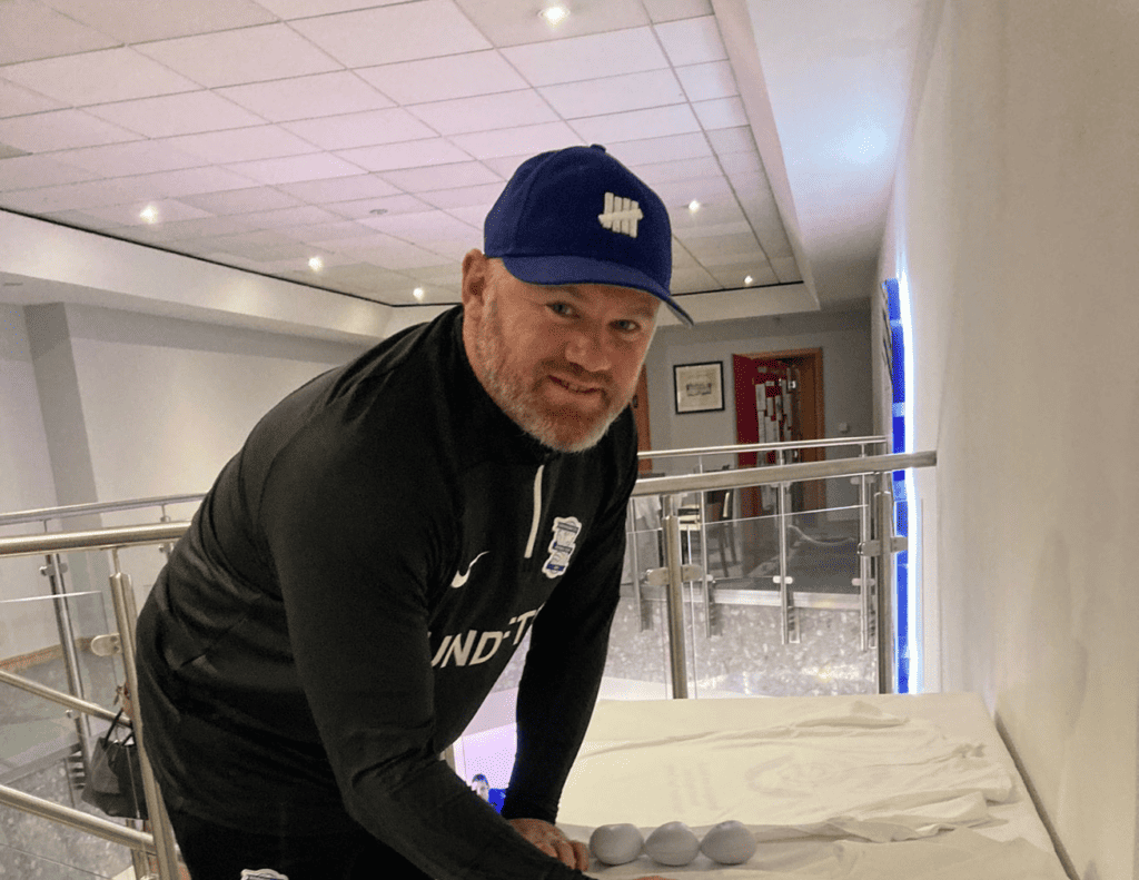 Wayne Rooney signing a shirt