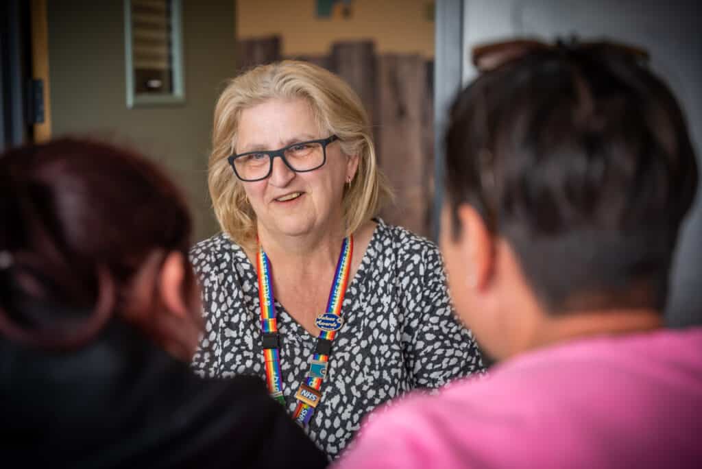 a picture of service users and a staff member talking