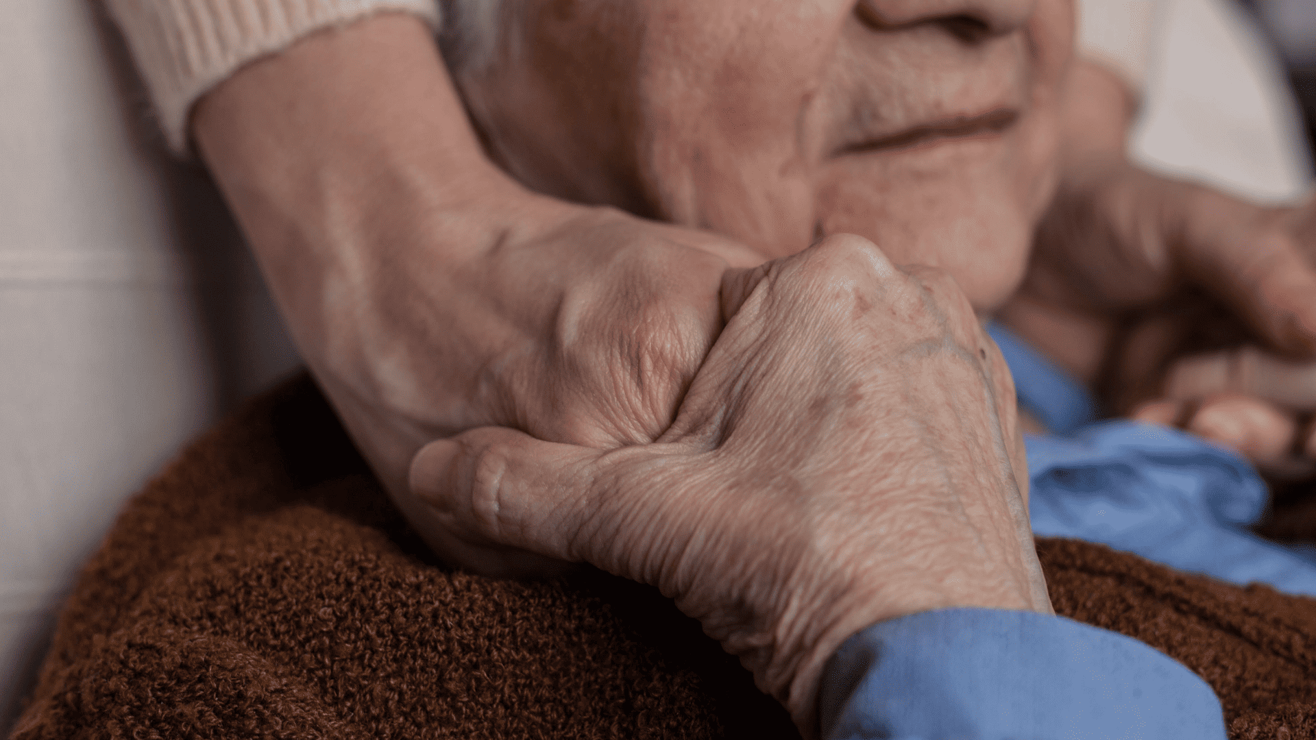 an older person holding someone's hand