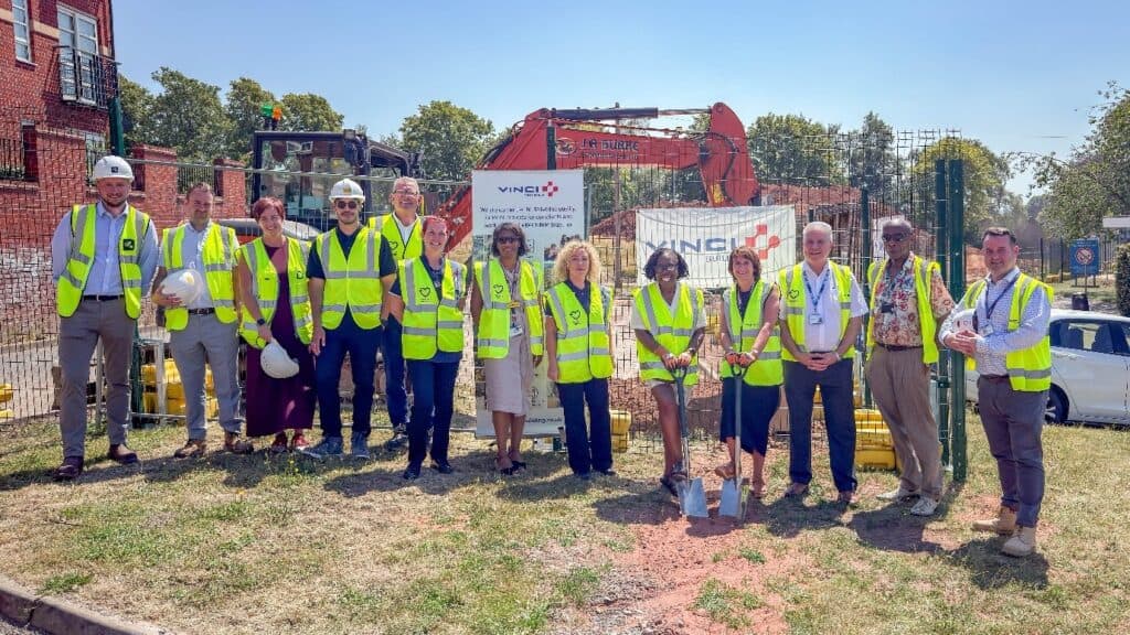 Group of officials and workers at Highcroft mental health construction site.