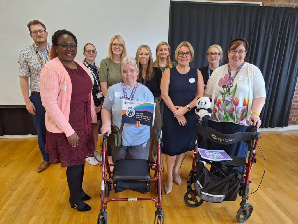 Group of diverse healthcare professionals and patients at a community event.